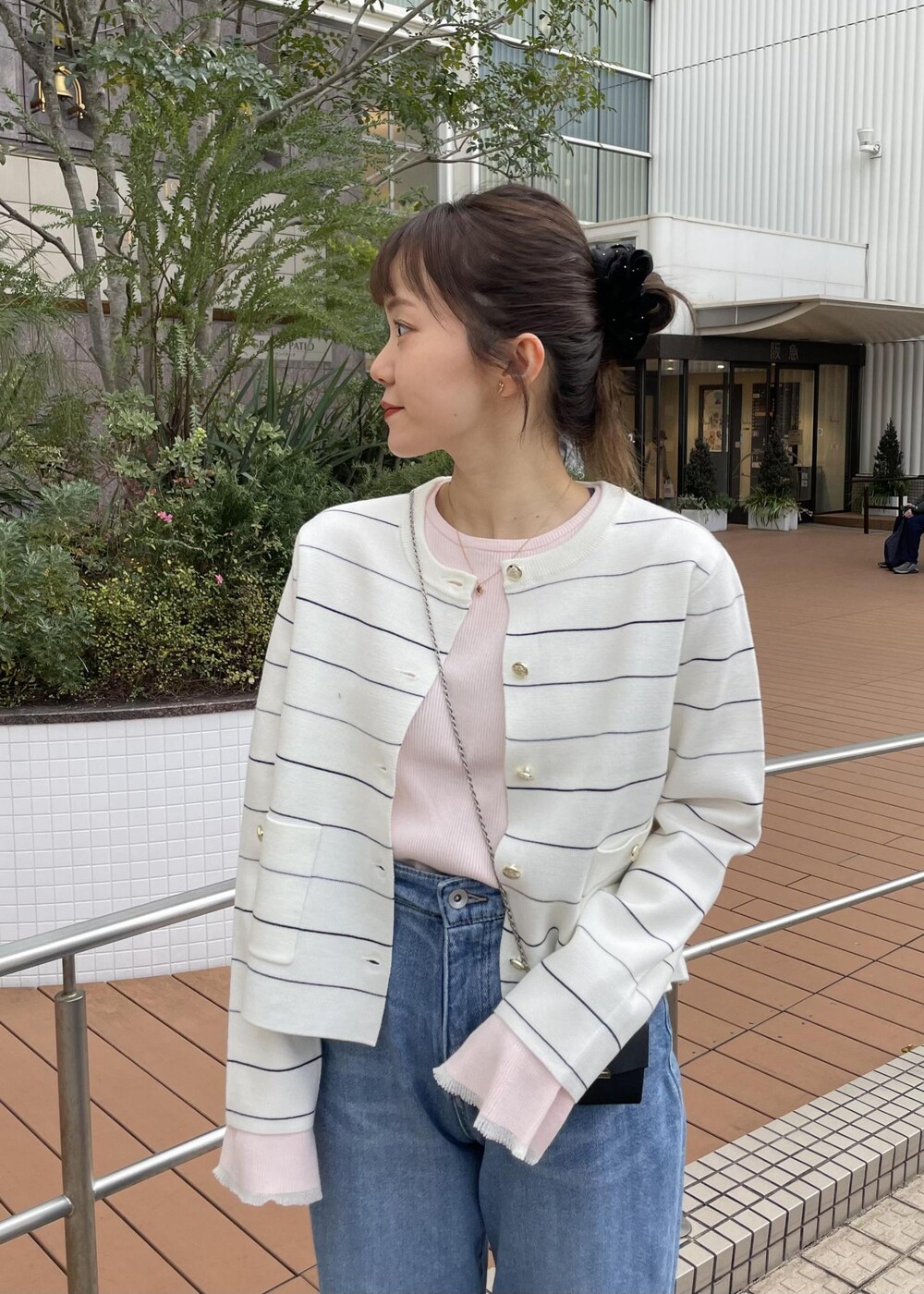 ブラック系のショルダーバッグ、ピンク系のニット/セーター、ホワイト系のカーディガン/ボレロを着用したレディースの冬コーディネートの5枚目の写真