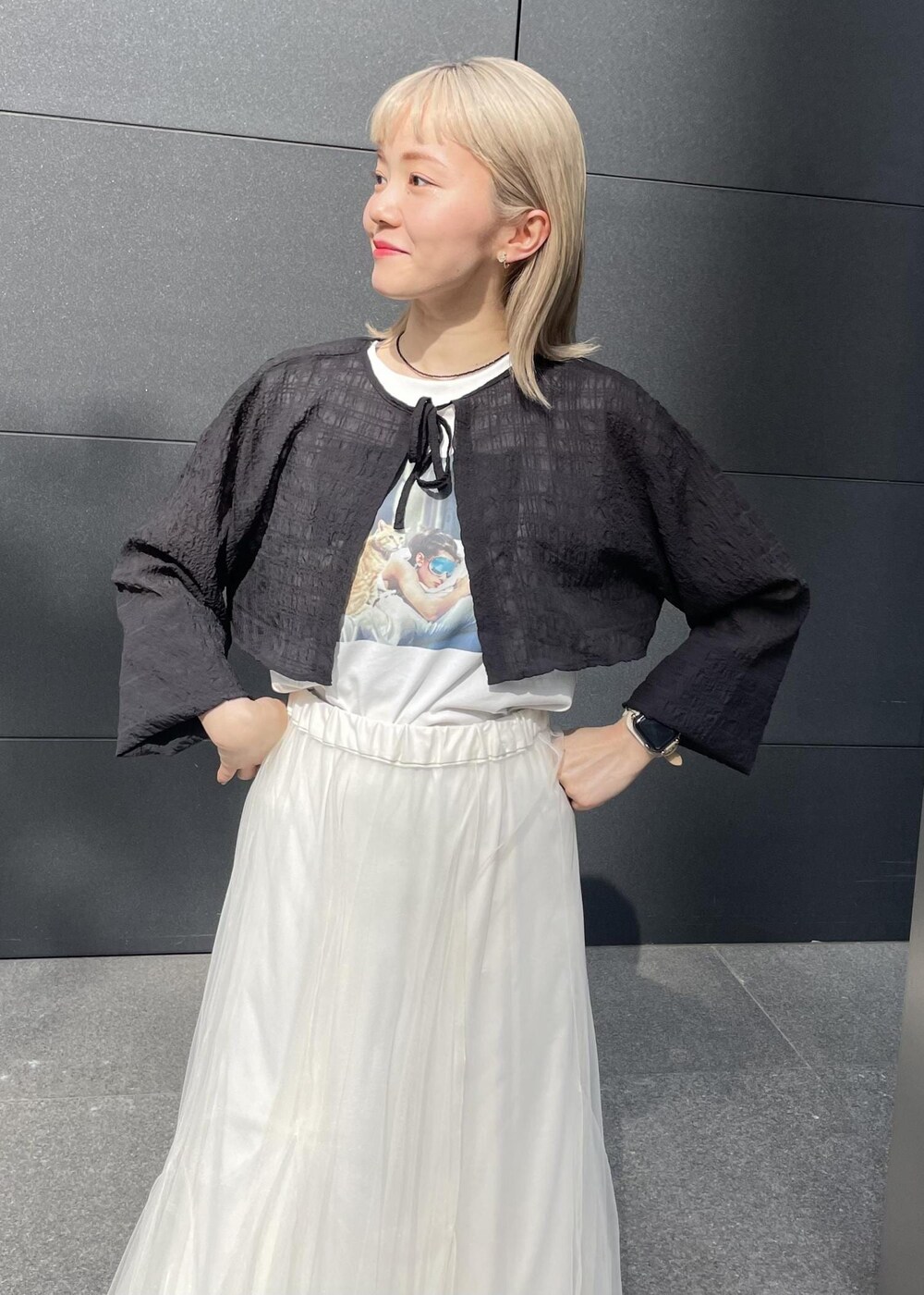 ブラック系のサンダル、ホワイト系のスカート、ブラック系のカーディガン/ボレロを着用したレディースの夏コーディネートの2枚目の写真