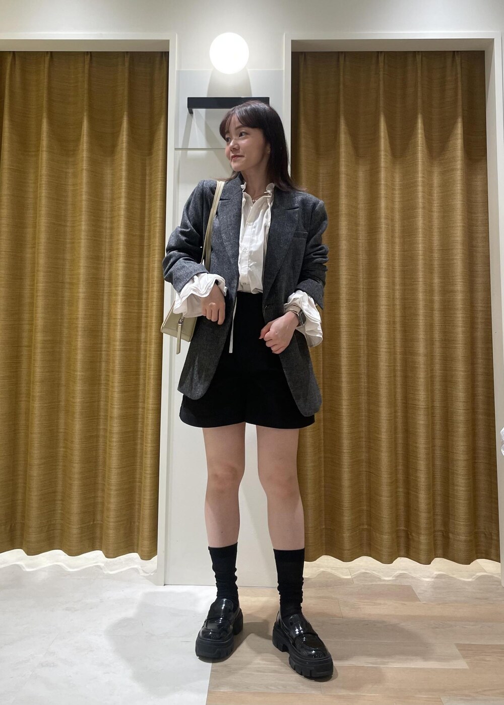 ブラック系のチノパンツ、ホワイト系のシャツ/ブラウス、ブラック系のテーラードジャケットを着用したレディースの秋コーディネートの7枚目の写真