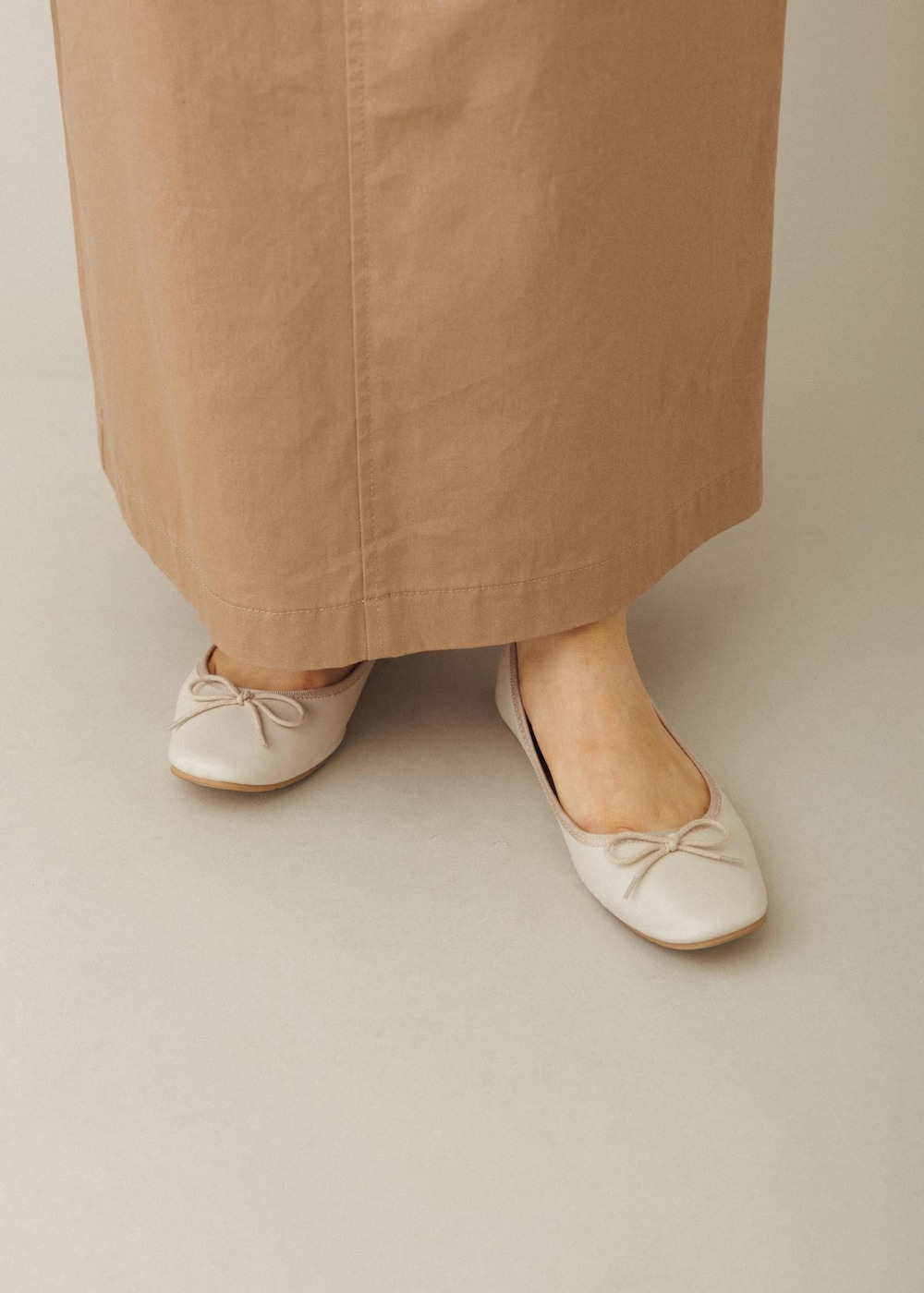 ホワイト系のショルダーバッグ、ベージュ系のスカート、ホワイト系のバレエシューズを着用したレディースの夏コーディネートの10枚目の写真