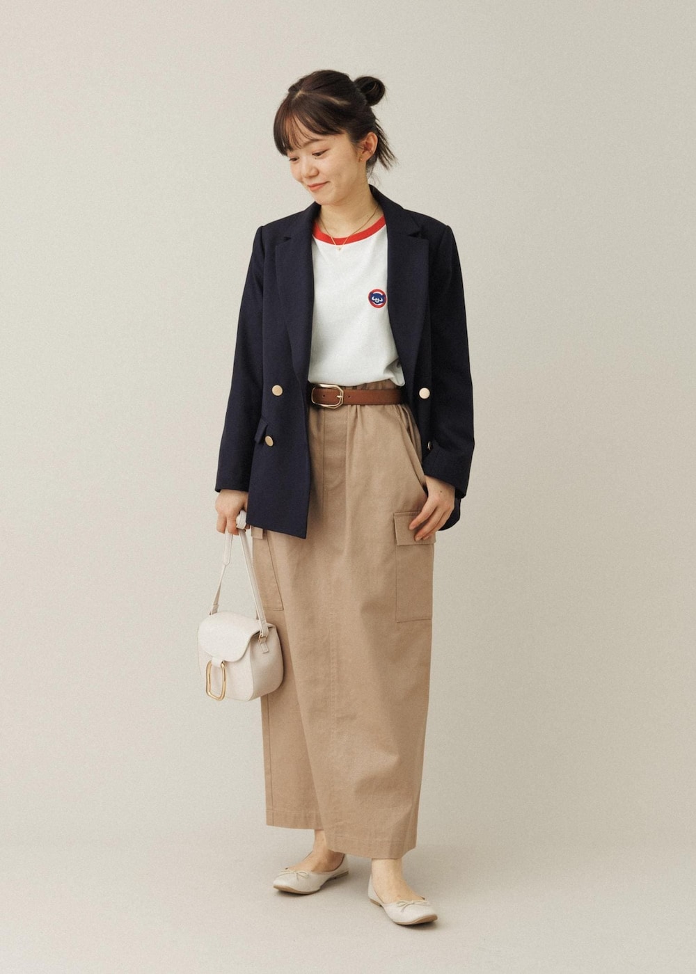 ホワイト系のショルダーバッグ、ベージュ系のスカート、ホワイト系のバレエシューズを着用したレディースの夏コーディネートの2枚目の写真