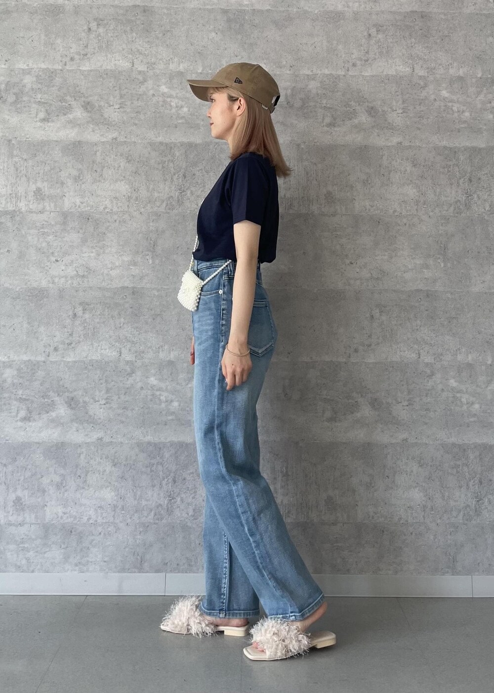 ブルー系のデニムパンツ、ベージュ系のサンダル、ブルー系のTシャツ/カットソーを着用したレディースの秋コーディネートの3枚目の写真