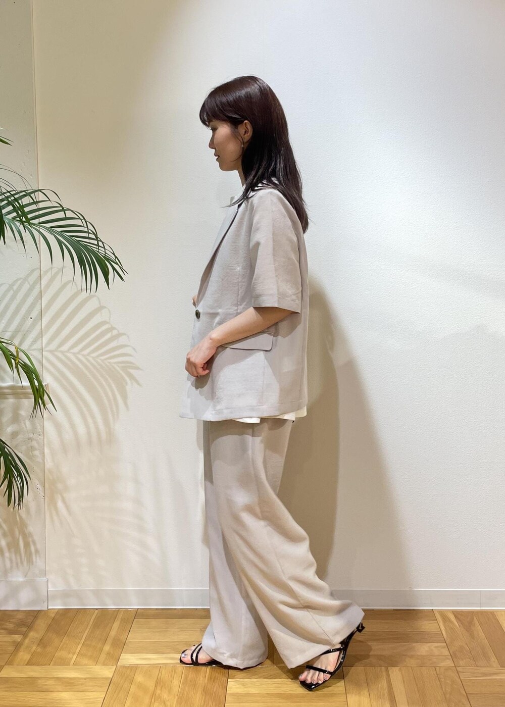 ベージュ系のテーラードジャケット、ブラック系のサンダル、ベージュ系のその他パンツを着用したレディースの夏コーディネートの4枚目の写真