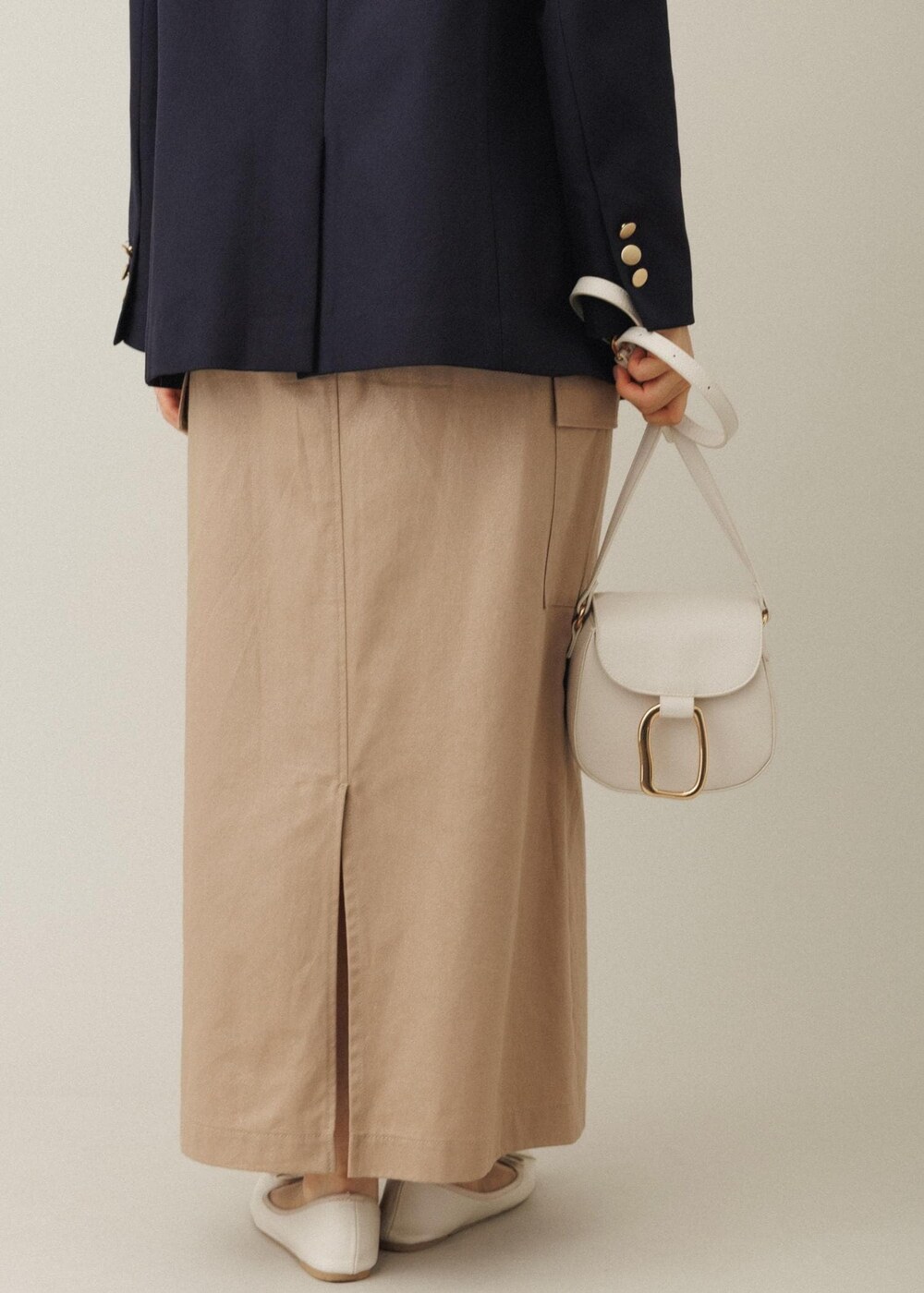 ホワイト系のショルダーバッグ、ベージュ系のスカート、ホワイト系のバレエシューズを着用したレディースの夏コーディネートの9枚目の写真