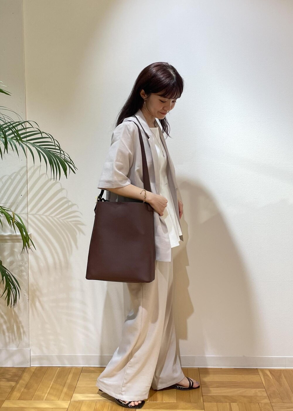 ベージュ系のテーラードジャケット、ブラック系のサンダル、ベージュ系のその他パンツを着用したレディースの夏コーディネートの2枚目の写真