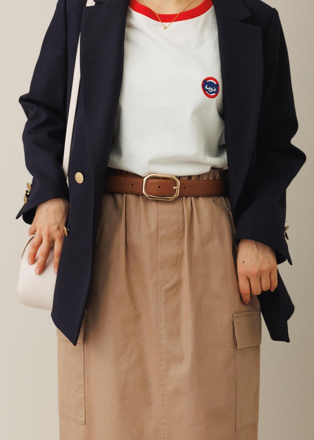 ホワイト系のショルダーバッグ、ベージュ系のスカート、ホワイト系のバレエシューズを着用したレディースの夏コーディネートの7枚目の写真