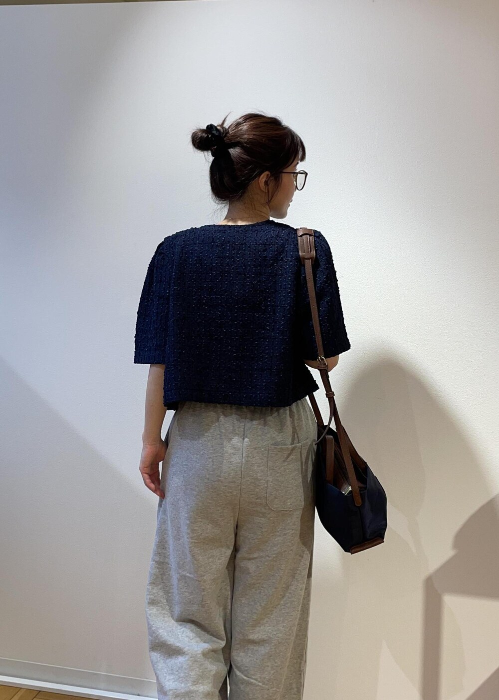 ブルー系のショルダーバッグ、グレー系のその他パンツ、ブルー系のノーカラージャケットを着用したレディースの春コーディネートの5枚目の写真