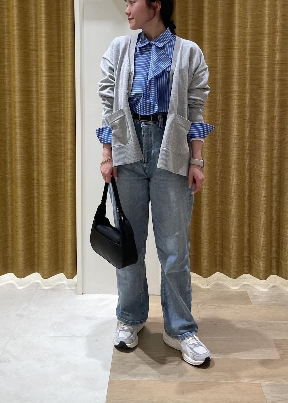 ブルー系のシャツ/ブラウス、グレー系のカーディガン/ボレロ、ブラック系のハンドバッグを着用したレディースの春コーディネートの7枚目の写真