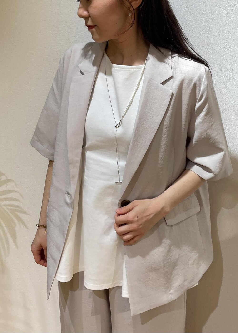 ベージュ系のテーラードジャケット、ブラック系のサンダル、ベージュ系のその他パンツを着用したレディースの夏コーディネートの5枚目の写真