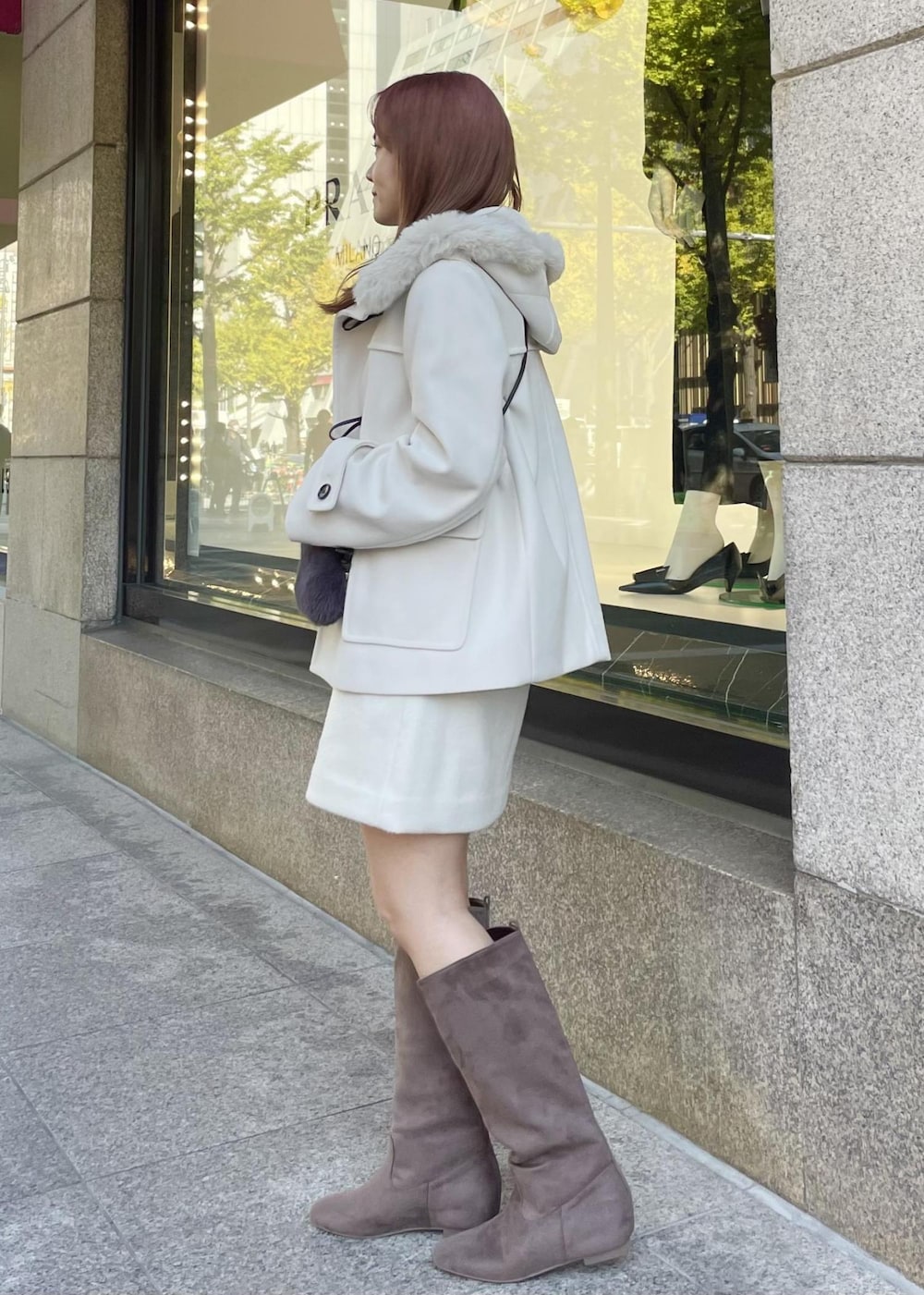 ホワイト系のニット/セーター、ホワイト系のダッフルコート、グレー系のショルダーバッグを着用したレディースの秋コーディネートの2枚目の写真