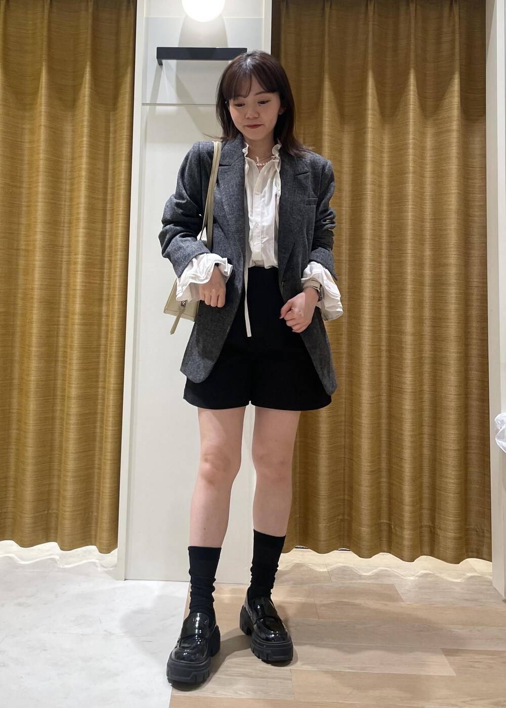 ブラック系のチノパンツ、ホワイト系のシャツ/ブラウス、ブラック系のテーラードジャケットを着用したレディースの秋コーディネートの2枚目の写真