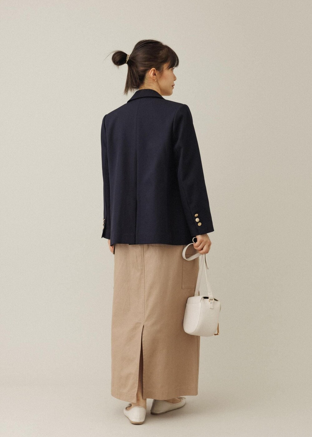 ホワイト系のショルダーバッグ、ベージュ系のスカート、ホワイト系のバレエシューズを着用したレディースの夏コーディネートの3枚目の写真