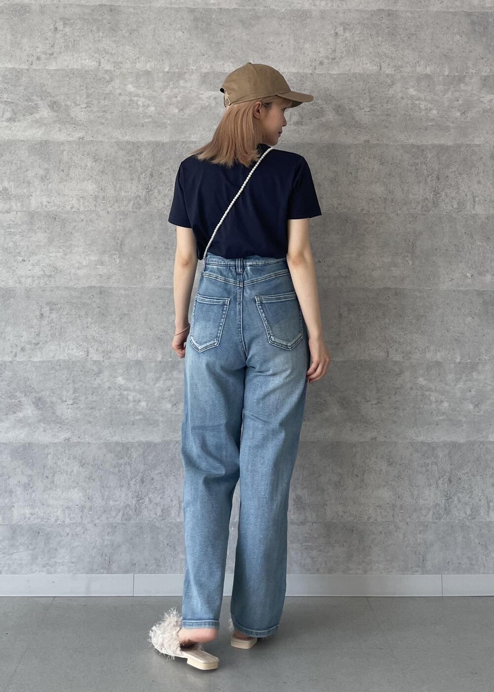 ブルー系のデニムパンツ、ベージュ系のサンダル、ブルー系のTシャツ/カットソーを着用したレディースの秋コーディネートの4枚目の写真