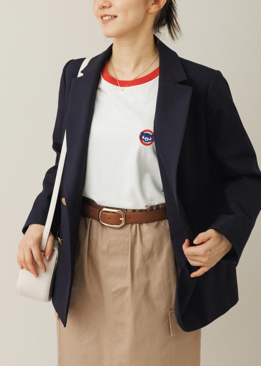 ホワイト系のショルダーバッグ、ベージュ系のスカート、ホワイト系のバレエシューズを着用したレディースの夏コーディネートの4枚目の写真