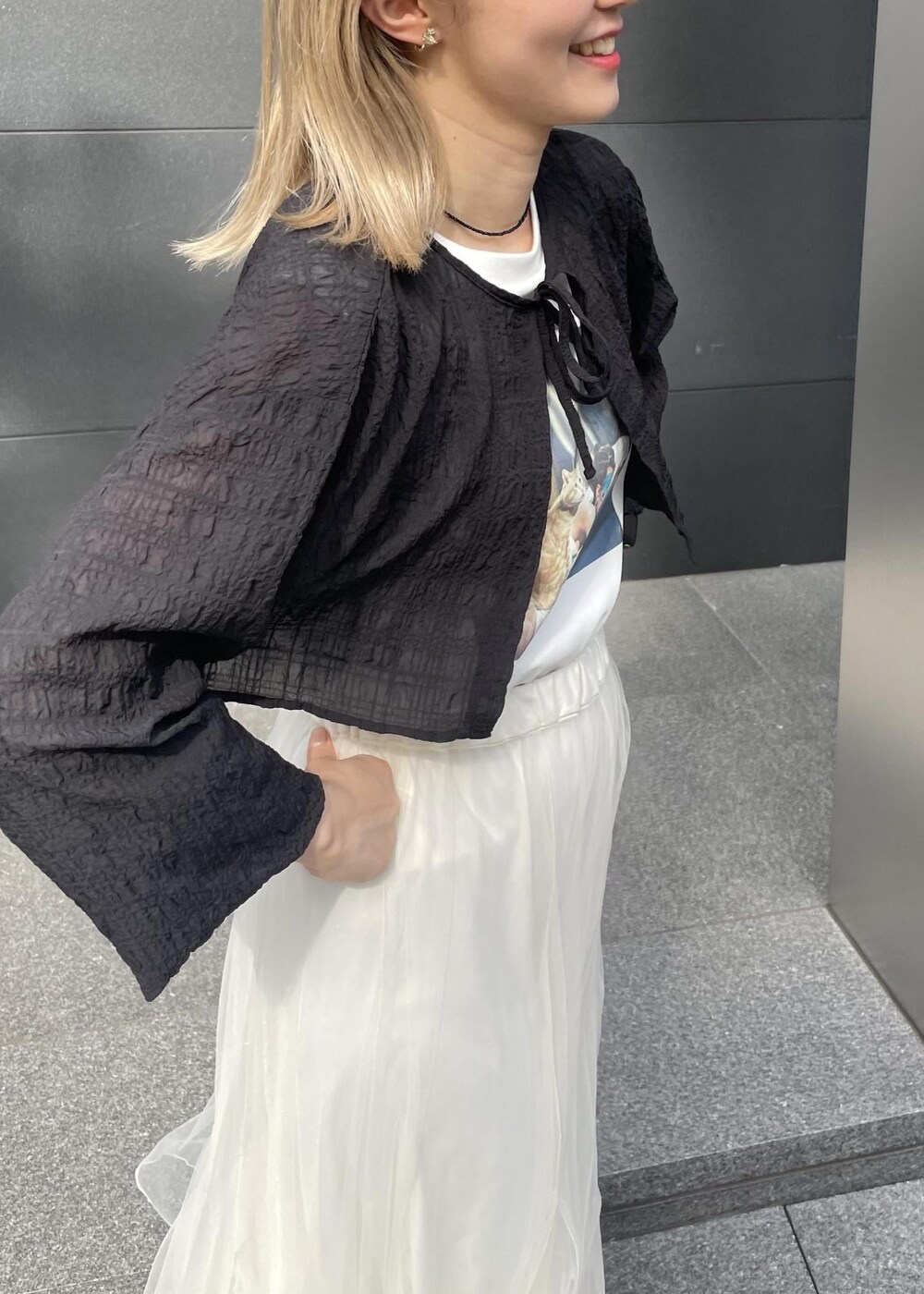 ブラック系のサンダル、ホワイト系のスカート、ブラック系のカーディガン/ボレロを着用したレディースの夏コーディネートの3枚目の写真