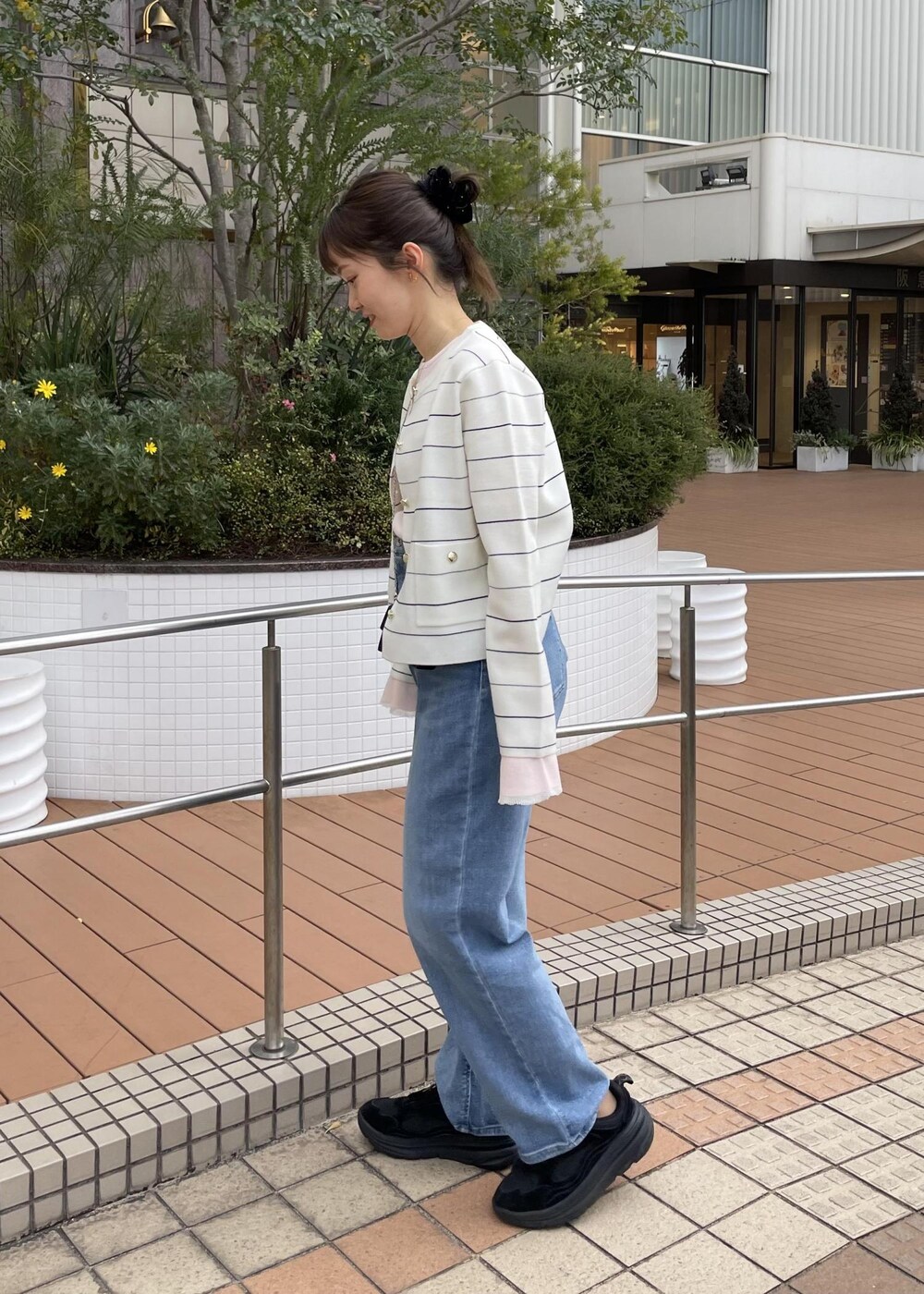 ブラック系のショルダーバッグ、ピンク系のニット/セーター、ホワイト系のカーディガン/ボレロを着用したレディースの冬コーディネートの3枚目の写真