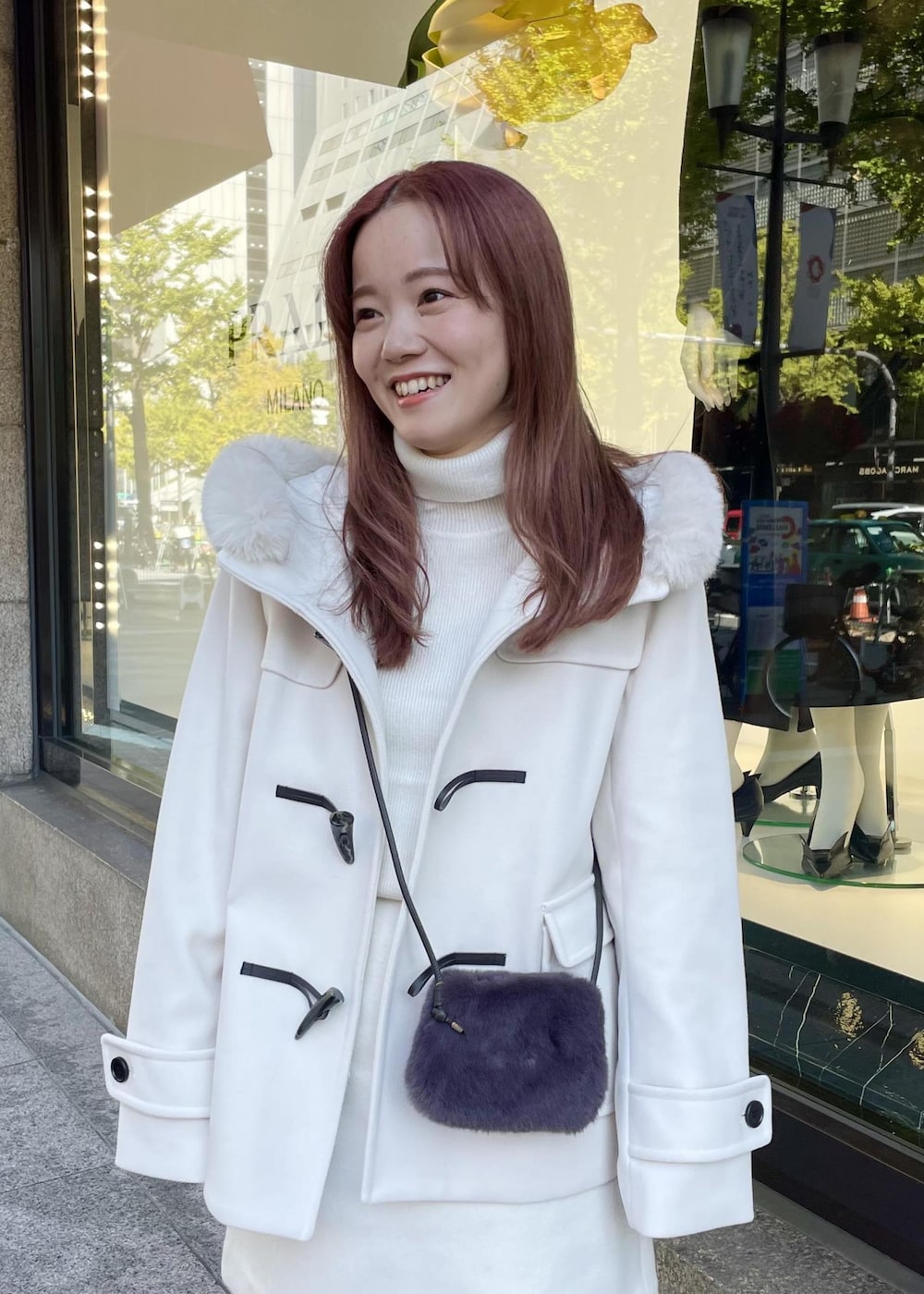 ホワイト系のニット/セーター、ホワイト系のダッフルコート、グレー系のショルダーバッグを着用したレディースの秋コーディネートの3枚目の写真