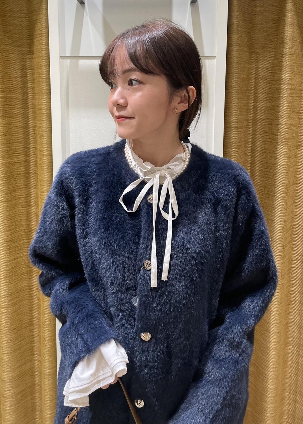 ブラック系のチノパンツ、ブラウン系のショルダーバッグ、ホワイト系のシャツ/ブラウスを着用したレディースの秋コーディネートの6枚目の写真