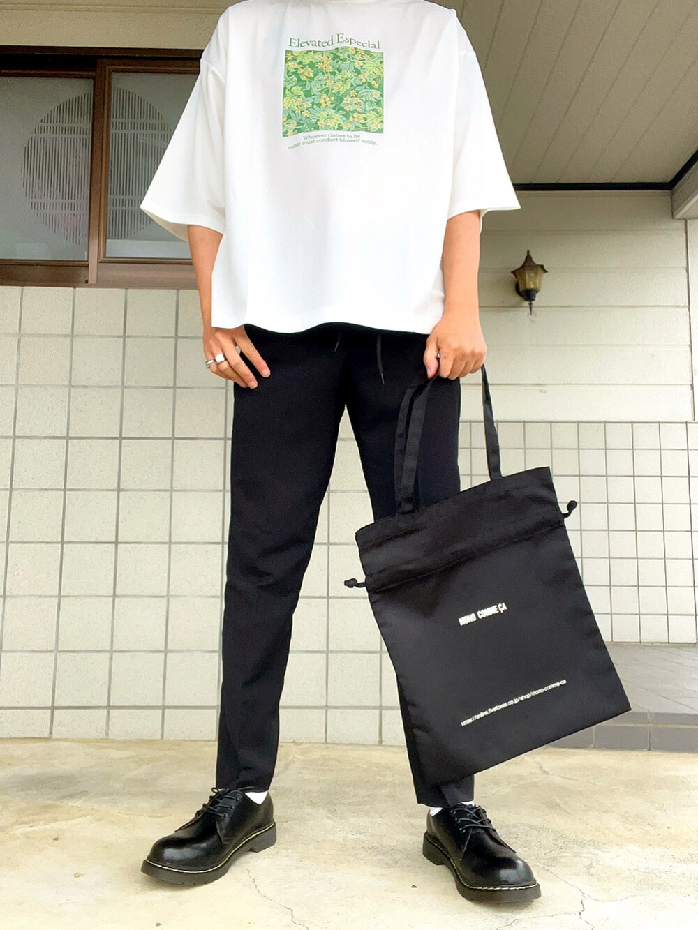 ホワイト系のTシャツ/カットソー、ブラック系のトートバッグ、ブラック系のブーツを着用したメンズの冬コーディネートの2枚目の写真