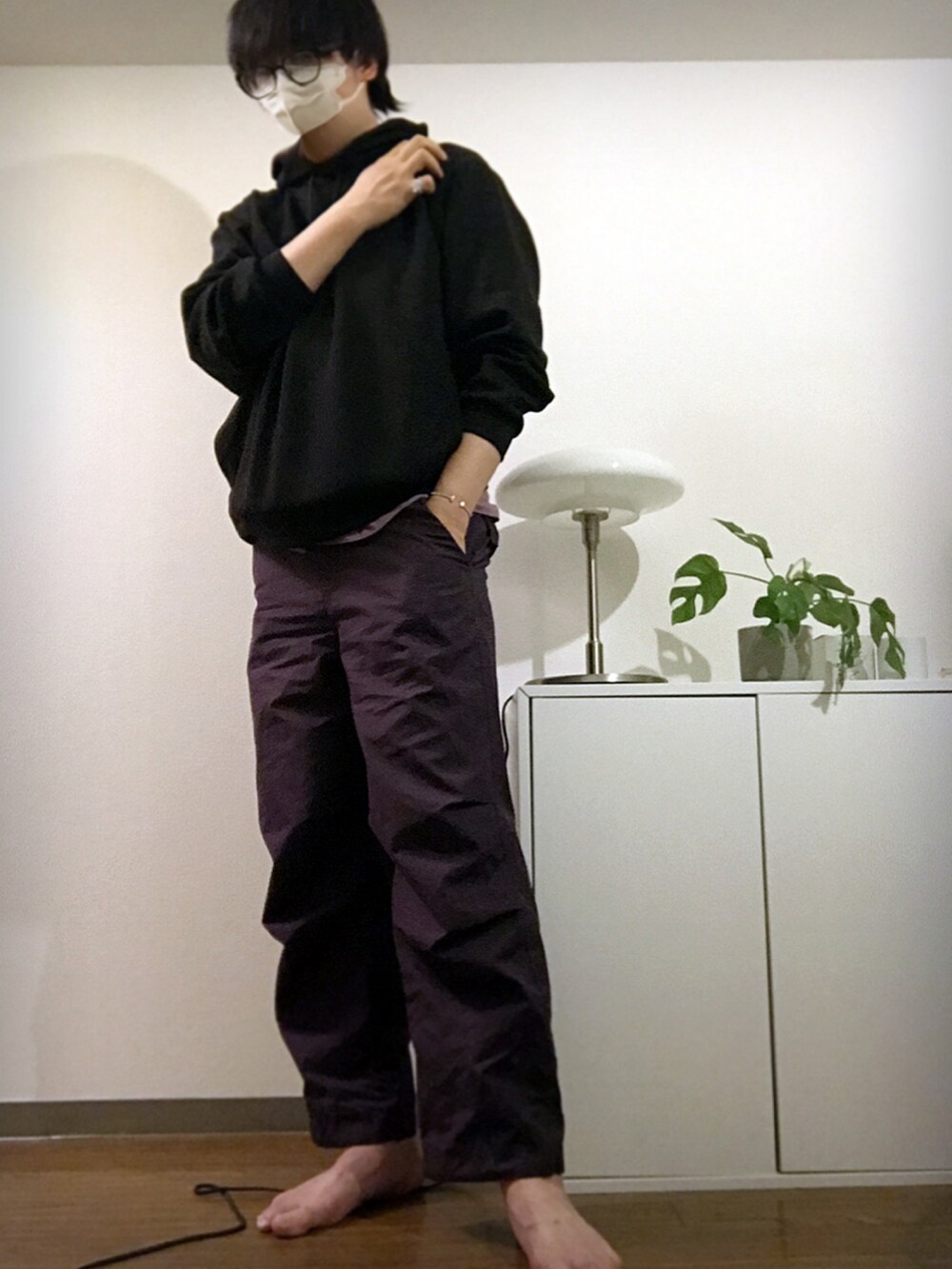 ブラック系のパーカー、パープル系のカーゴパンツ、ホワイト系のブレスレットを着用したメンズの冬コーディネートの2枚目の写真