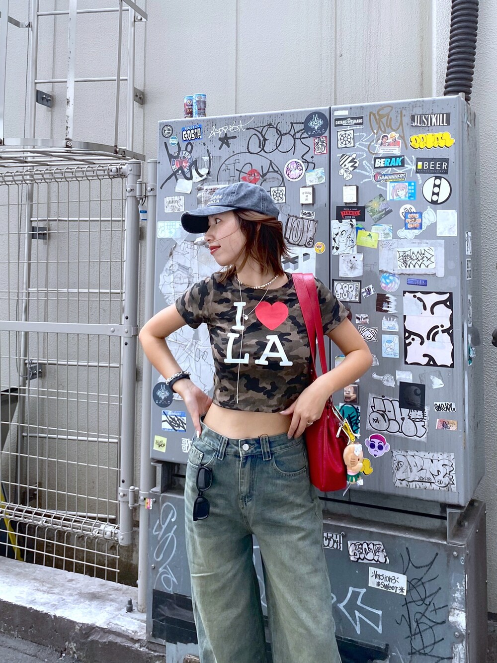 ブルー系のデニムパンツ、その他のTシャツ/カットソー、レッド系のショルダーバッグを着用したレディースの夏コーディネートの4枚目の写真