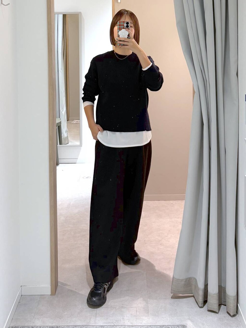 ホワイト系のTシャツ/カットソー、ブルー系のニット/セーター、ブラック系のスウェットパンツを着用したレディースの冬コーディネートの2枚目の写真