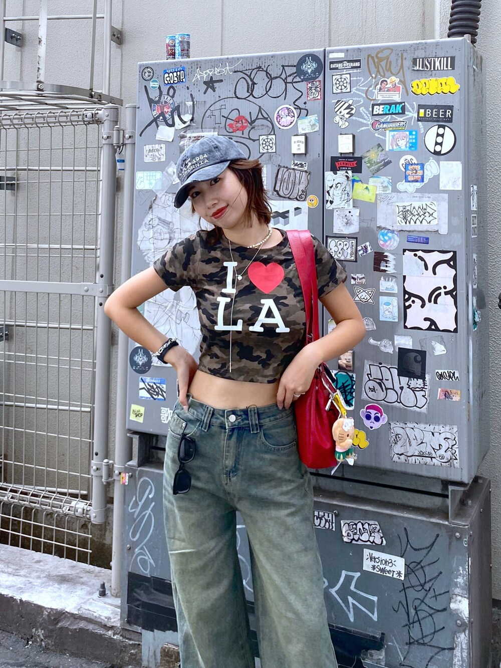 ブルー系のデニムパンツ、その他のTシャツ/カットソー、レッド系のショルダーバッグを着用したレディースの夏コーディネートの3枚目の写真
