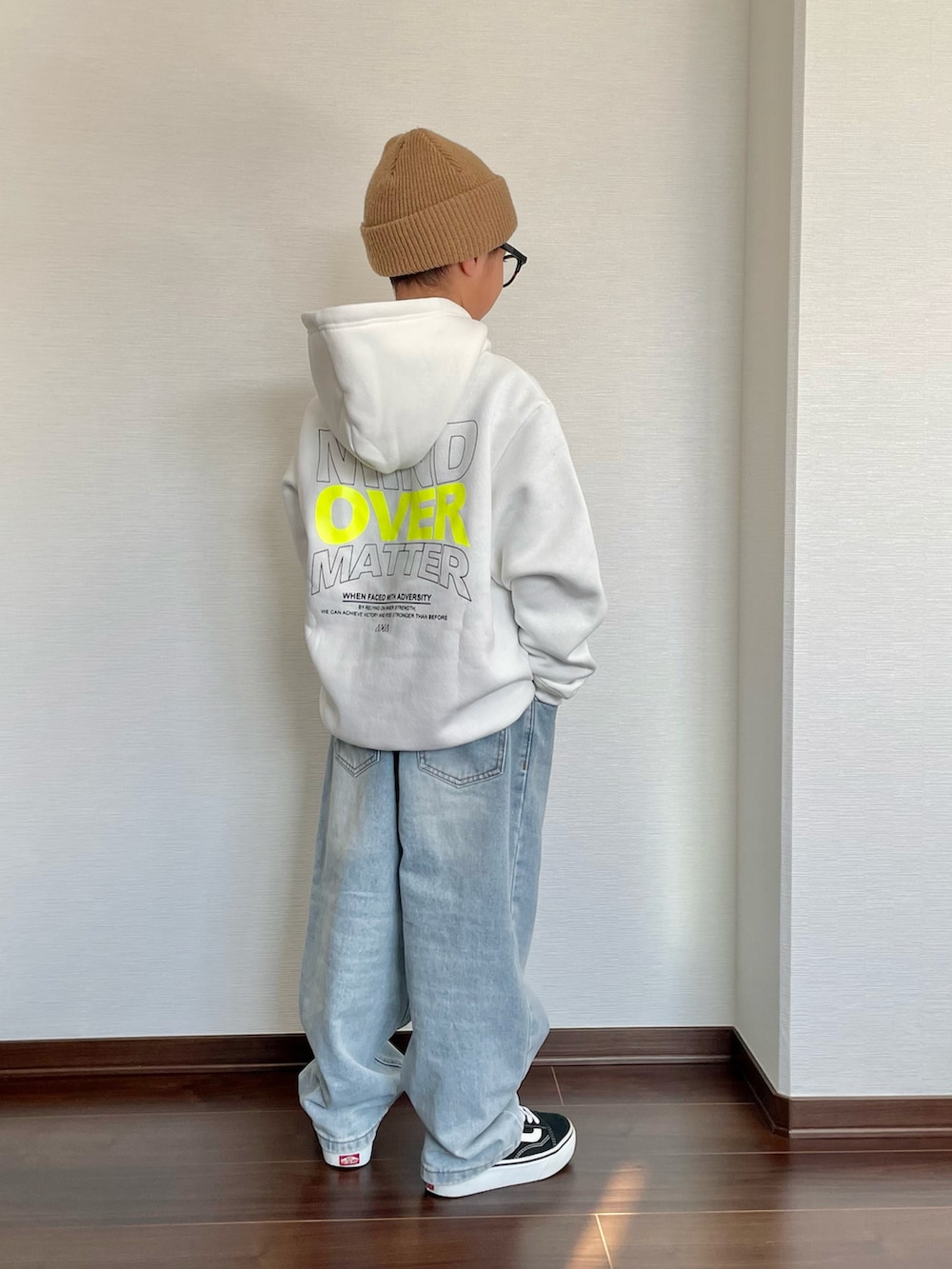 ホワイト系のパーカー、ブルー系のデニムパンツ、ブラック系のスニーカーを着用したキッズの冬コーディネートの2枚目の写真