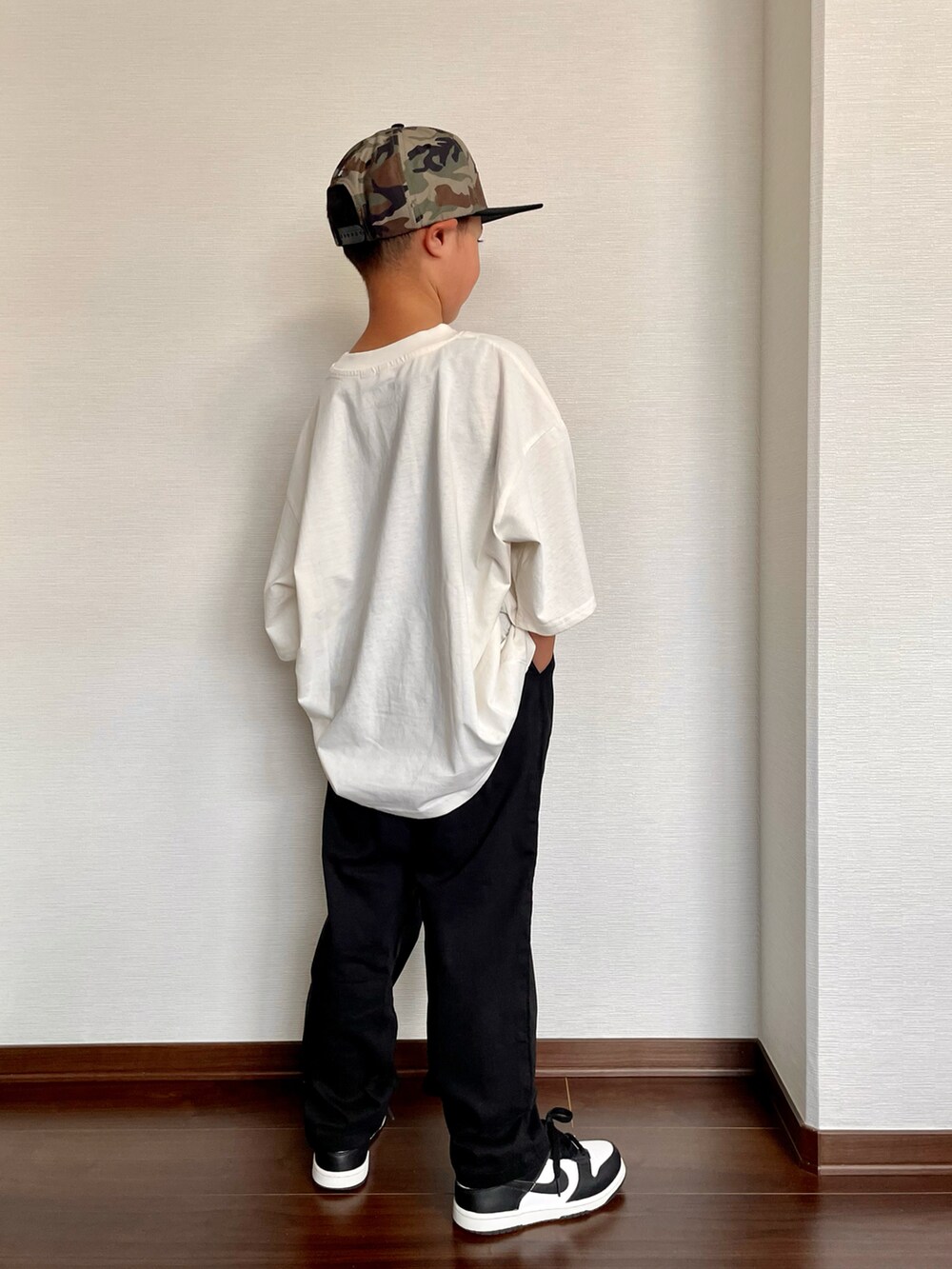 ブラック系のスニーカー、ホワイト系のTシャツ/カットソー、ブラック系のカーゴパンツを着用したキッズの夏コーディネートの3枚目の写真