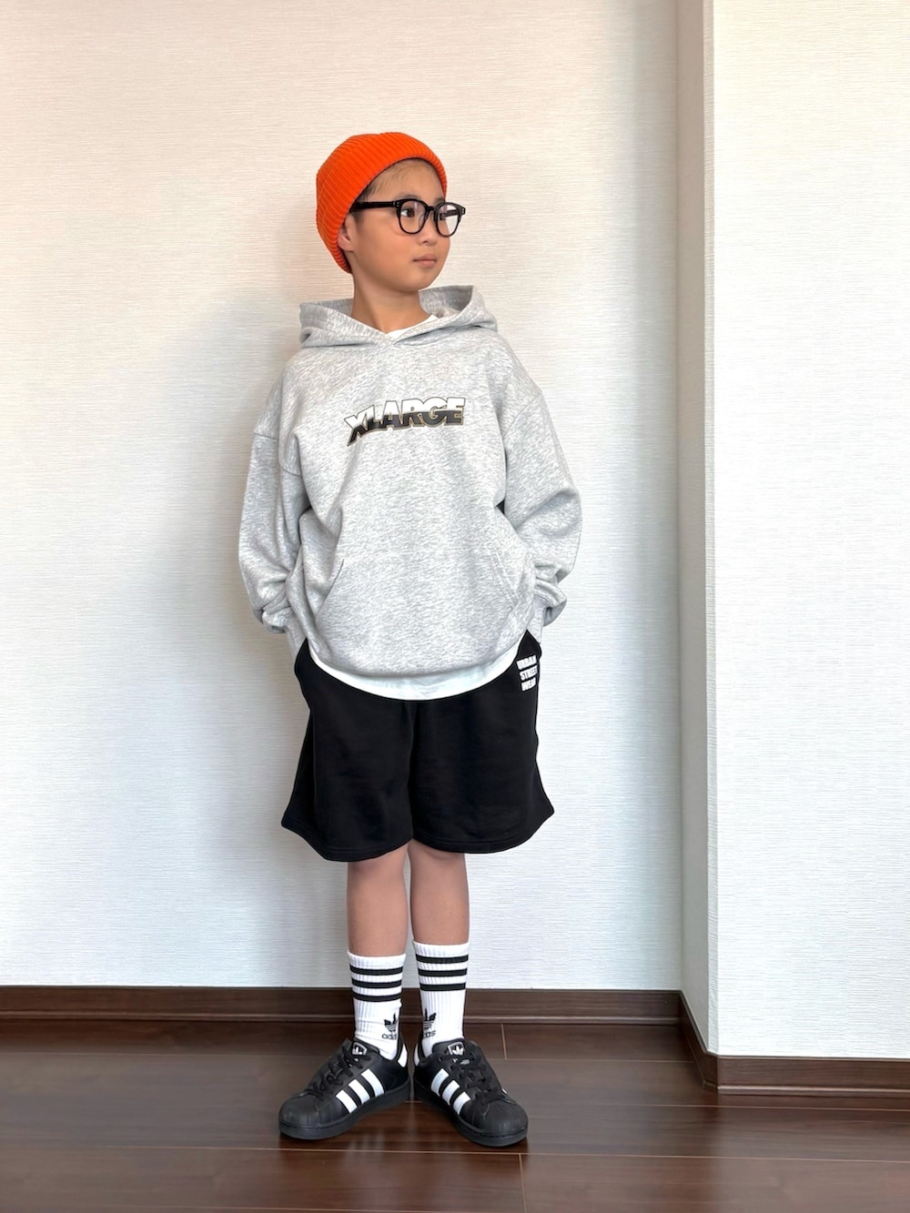 グレー系のパーカー、ブラック系のスウェットパンツ、ブラック系のスニーカーを着用したキッズの冬コーディネートの2枚目の写真