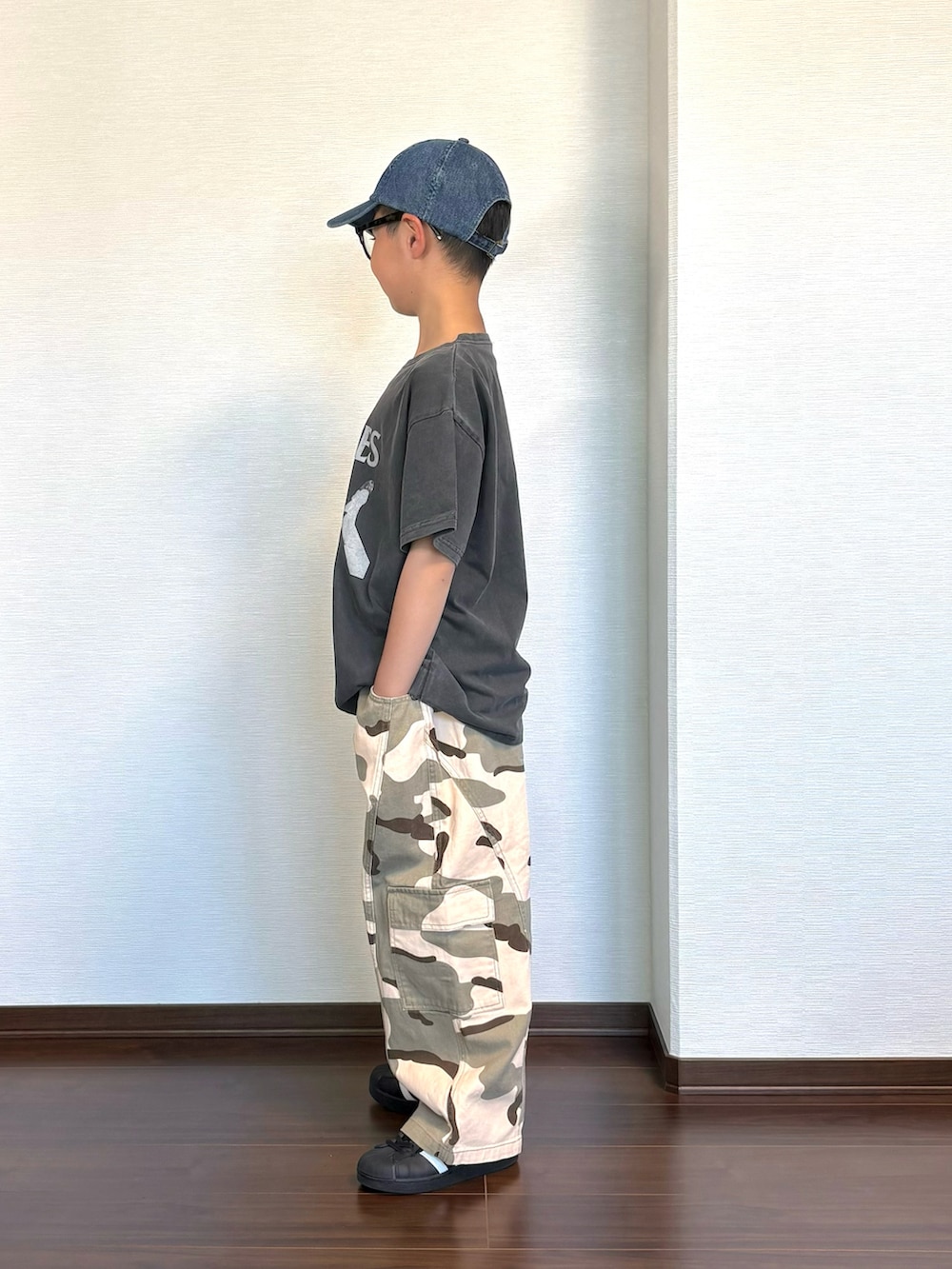 グリーン系のカーゴパンツ、ブラック系のスニーカー、ブラック系のTシャツ/カットソーを着用したキッズの春コーディネートの2枚目の写真