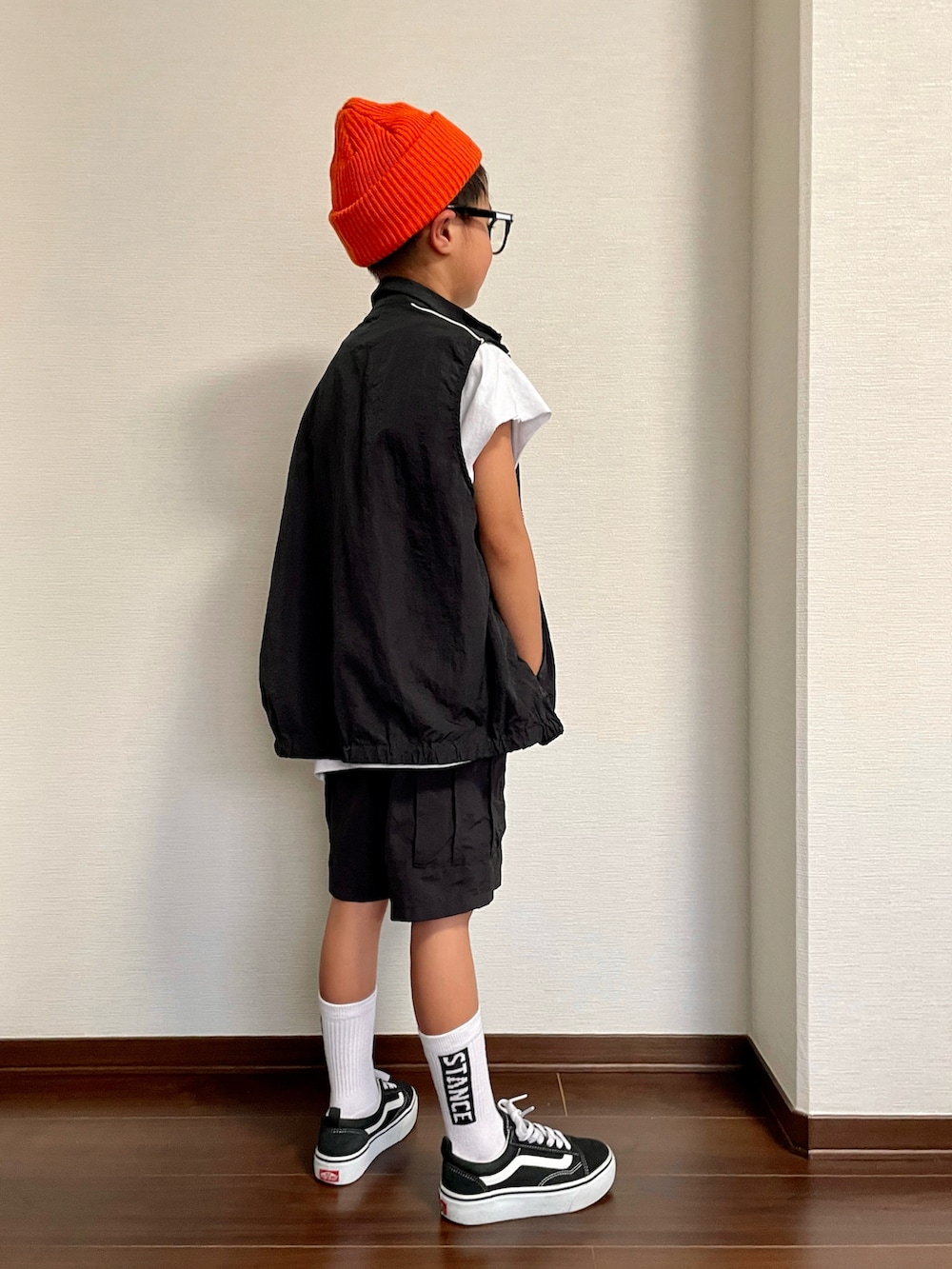 ブラック系のベスト、ホワイト系のTシャツ/カットソー、ブラック系のカーゴパンツを着用したキッズの夏コーディネートの2枚目の写真