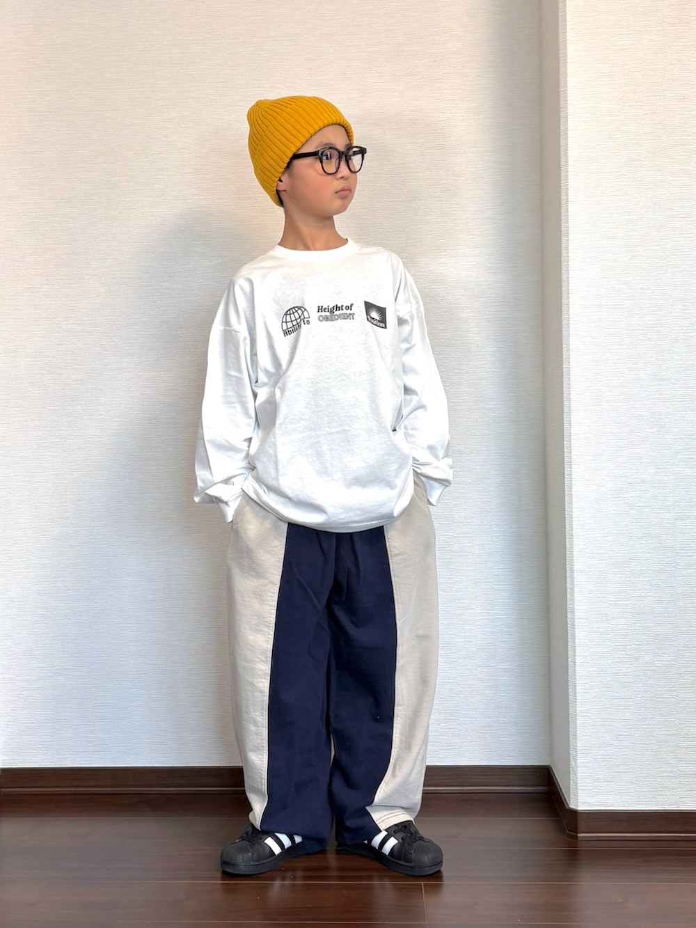 ホワイト系のTシャツ/カットソー、ブラック系のスニーカー、ホワイト系のスウェットパンツを着用したキッズの春コーディネートの2枚目の写真