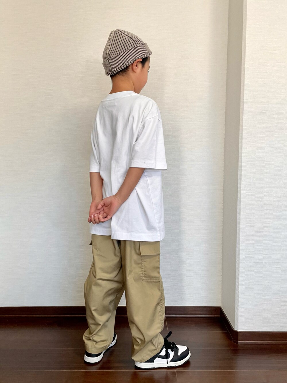 ホワイト系のTシャツ/カットソー、ベージュ系のカーゴパンツ、ブラック系のスニーカーを着用したキッズの夏コーディネートの2枚目の写真