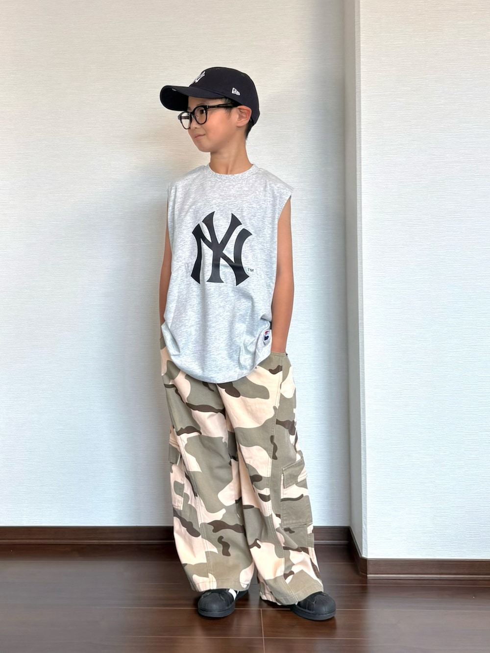 グリーン系のカーゴパンツ、ブラック系のスニーカー、グレー系のタンクトップを着用したキッズの夏コーディネートの2枚目の写真