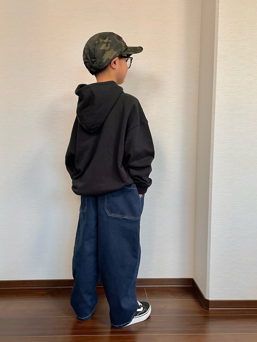 ブラック系のその他トップス、ブルー系のデニムパンツ、ブラック系のスニーカーを着用したキッズの冬コーディネートの2枚目の写真