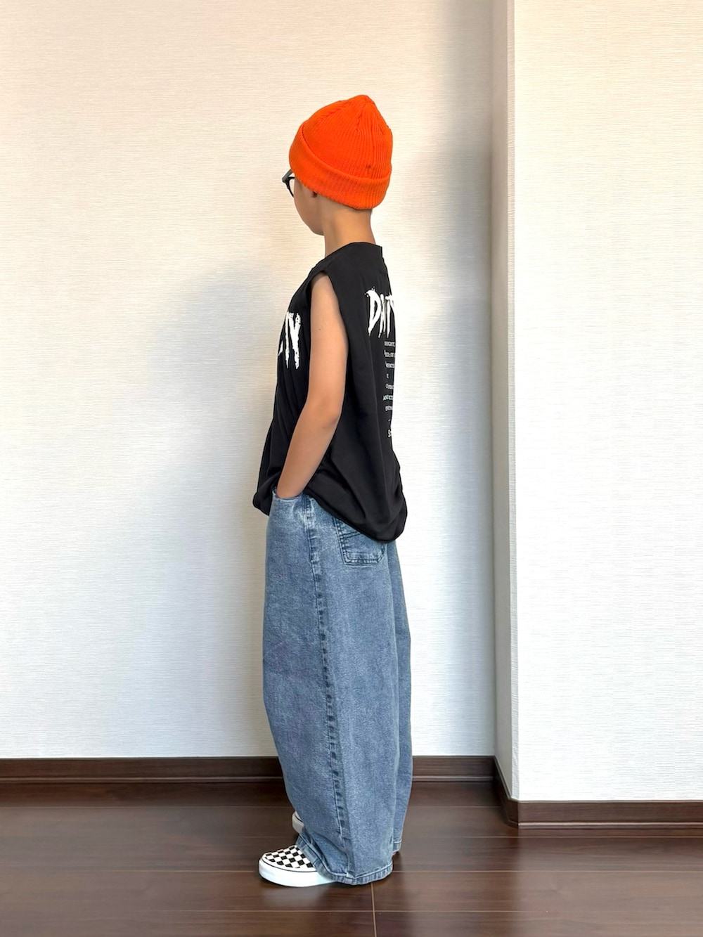 ブラック系のタンクトップ、ブルー系のデニムパンツ、ブラック系のスニーカーを着用したキッズの夏コーディネートの2枚目の写真