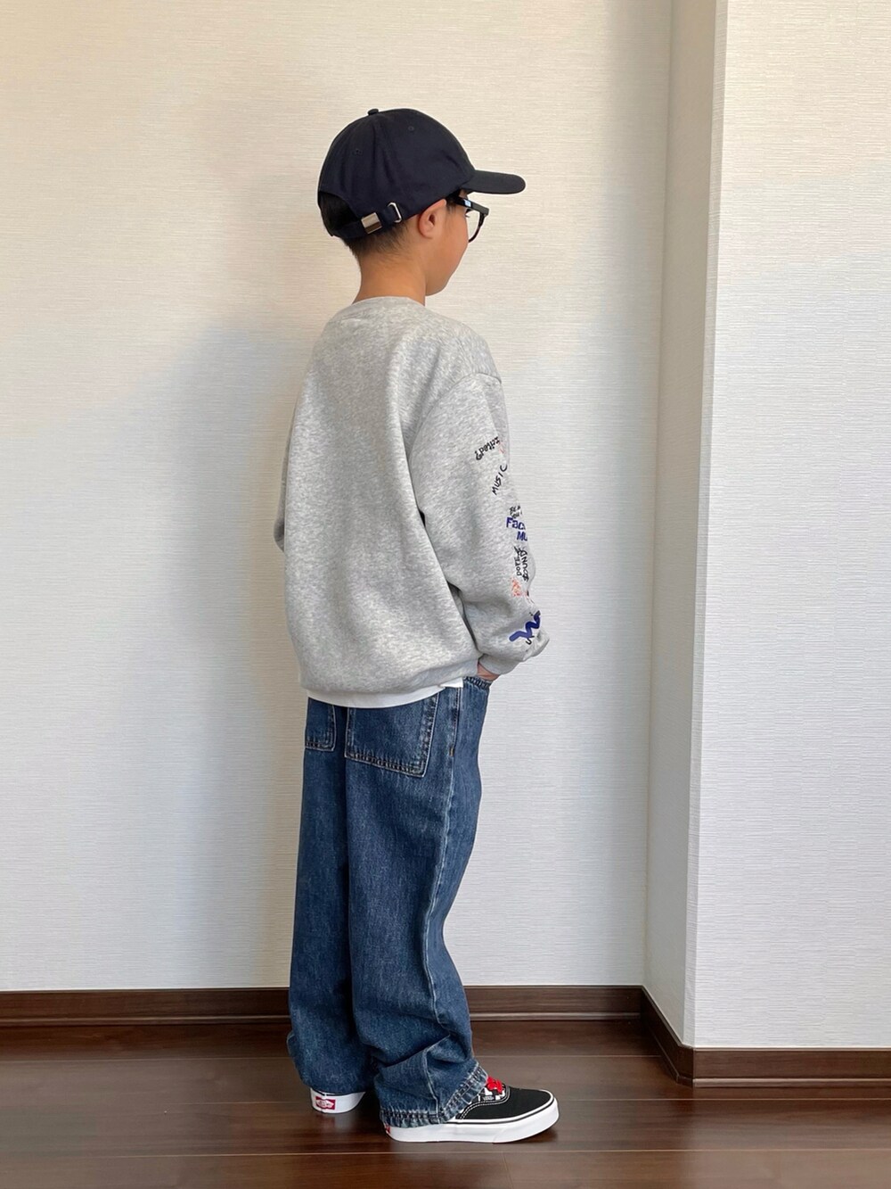 グレー系のスウェット、ブルー系のデニムパンツ、その他のスニーカーを着用したキッズの冬コーディネートの2枚目の写真