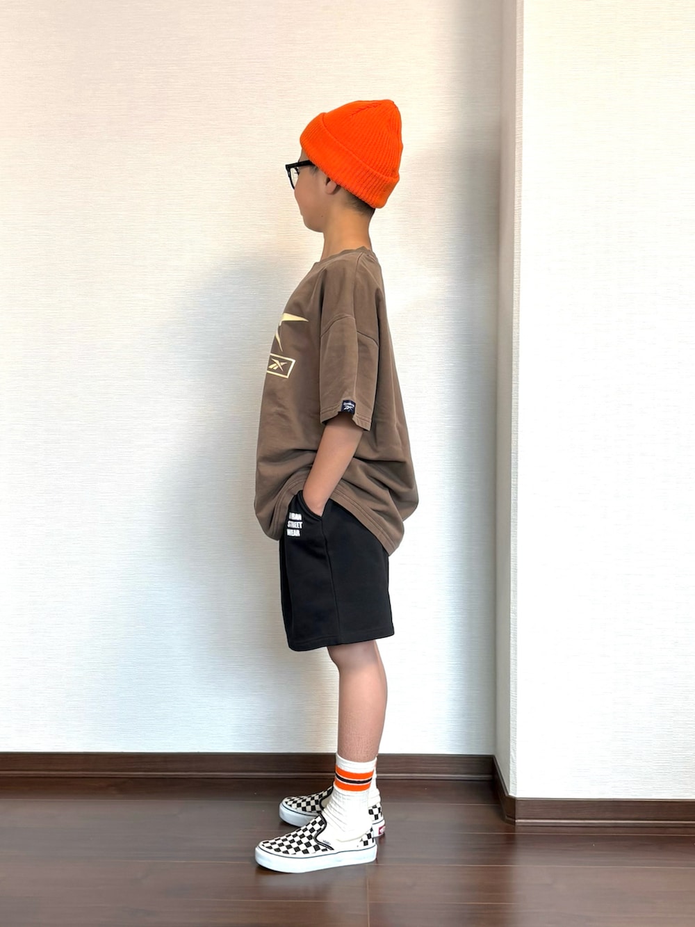 ブラウン系のTシャツ/カットソー、ブラック系のスウェットパンツ、ブラック系のスニーカーを着用したキッズの春コーディネートの2枚目の写真