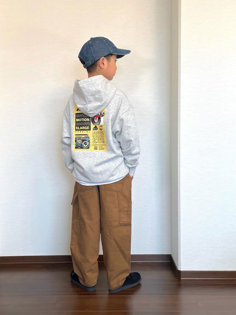 グレー系のパーカー、ブラウン系のカーゴパンツ、ブラック系のシューズを着用したキッズの冬コーディネートの2枚目の写真