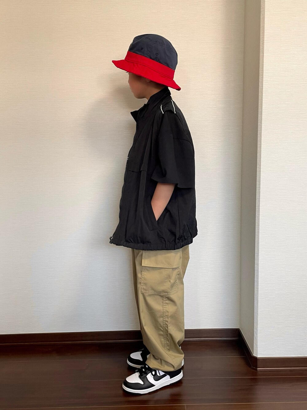 ブラック系のベスト、ブラック系のTシャツ/カットソー、ベージュ系のカーゴパンツを着用したキッズの春コーディネートの2枚目の写真