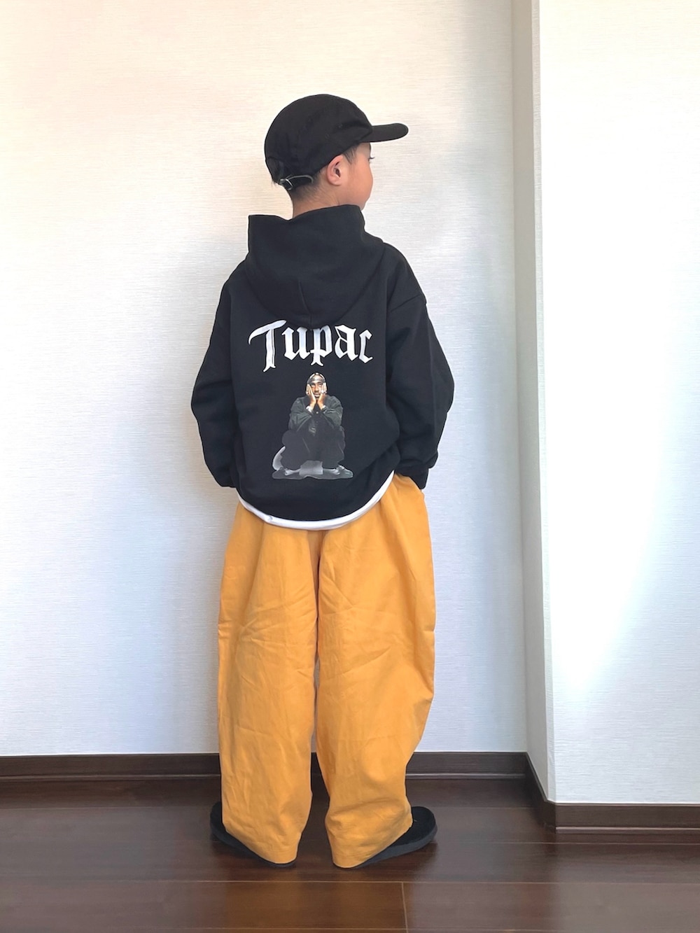 ブラック系のパーカー、イエロー系のカーゴパンツ、ブラック系のシューズを着用したキッズの冬コーディネートの2枚目の写真