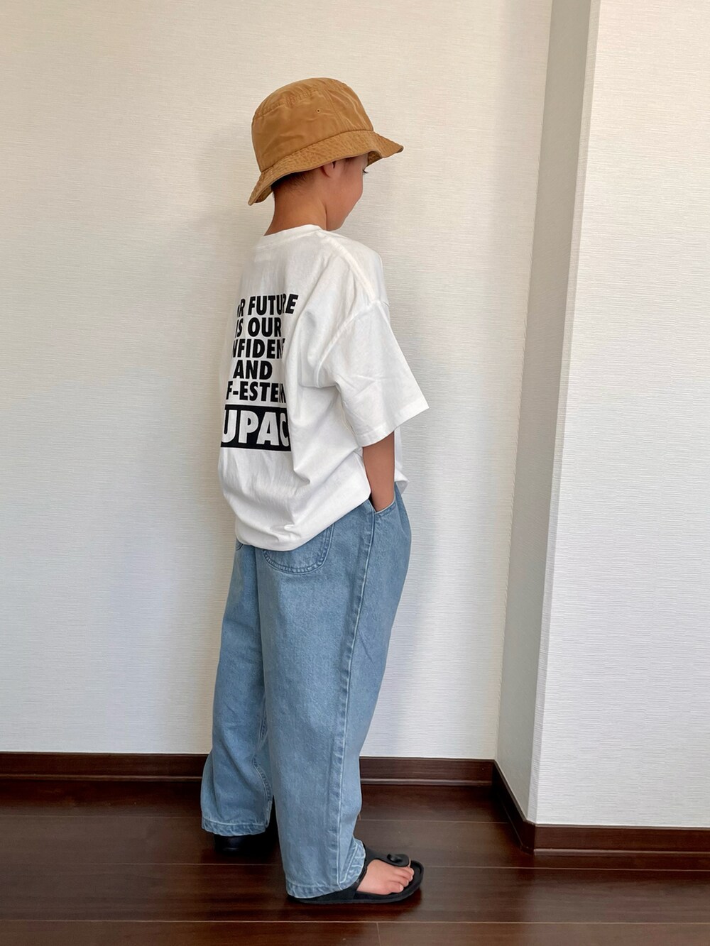ホワイト系のTシャツ/カットソー、ブルー系のデニムパンツ、ブラック系のサンダルを着用したキッズの夏コーディネートの2枚目の写真
