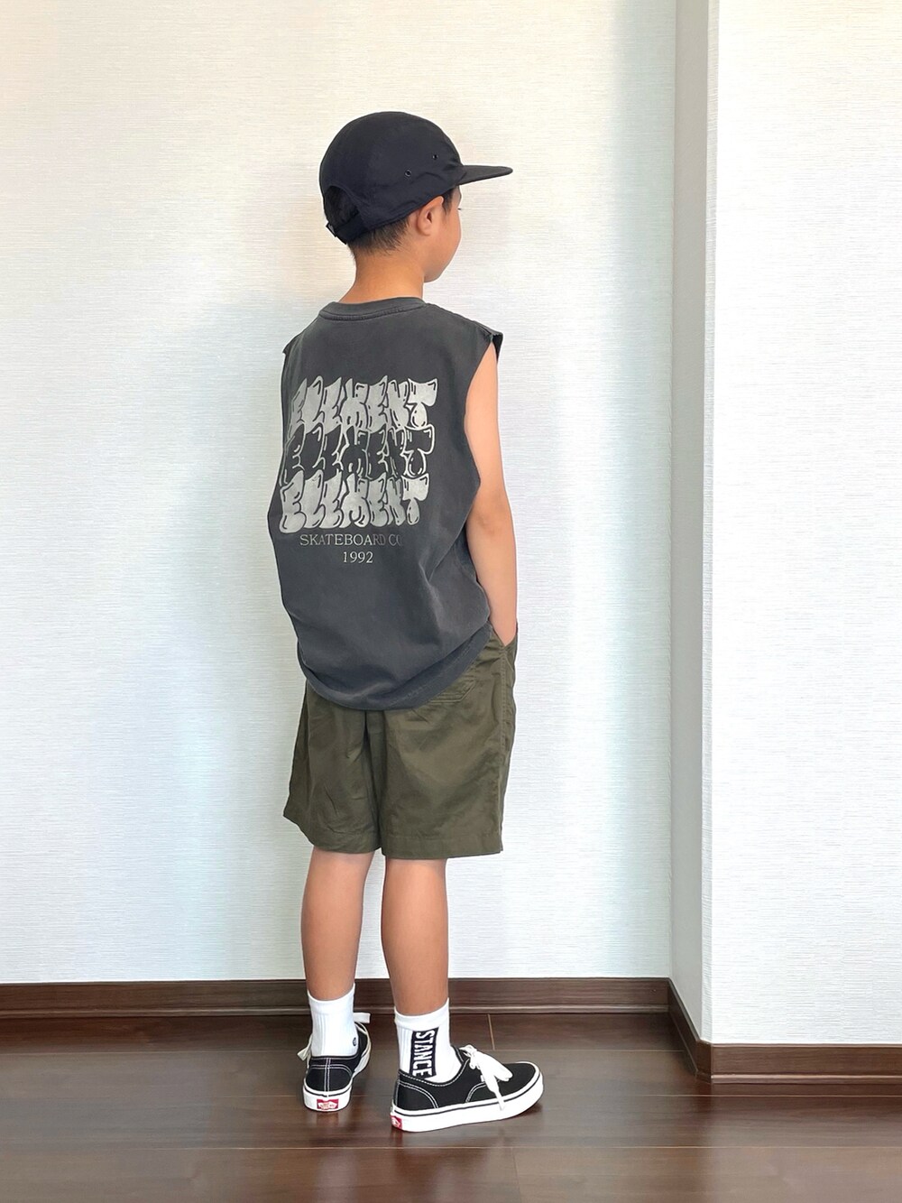 ブラック系のタンクトップ、ブラック系のスニーカー、グリーン系のパンツを着用したキッズの夏コーディネートの2枚目の写真