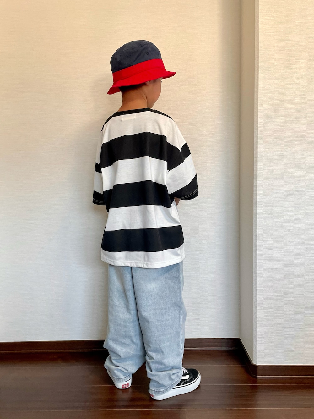 ブラック系のTシャツ/カットソー、ブルー系のデニムパンツ、ブラック系のスニーカーを着用したキッズの春コーディネートの2枚目の写真