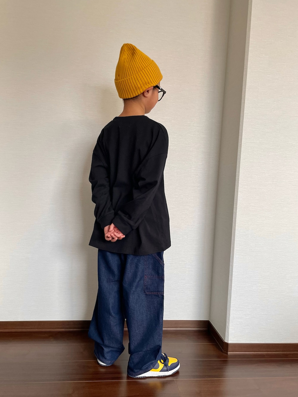 ブラック系のTシャツ/カットソー、ブルー系のデニムパンツ、イエロー系のスニーカーを着用したキッズの秋コーディネートの3枚目の写真