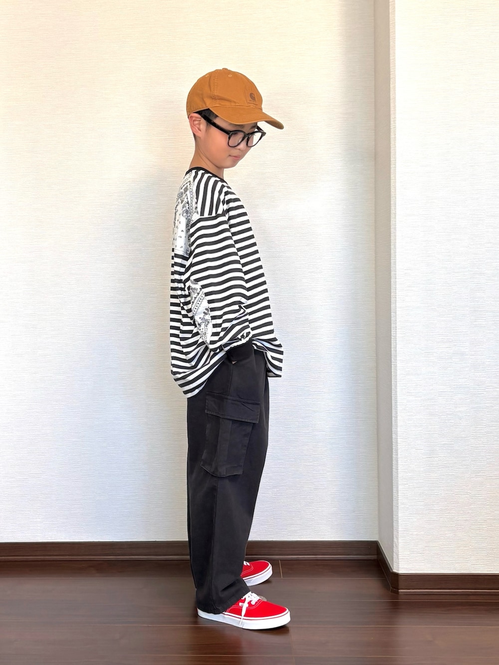 ブラック系のカーゴパンツ、ブラック系のTシャツ/カットソー、レッド系のスニーカーを着用したキッズの春コーディネートの2枚目の写真