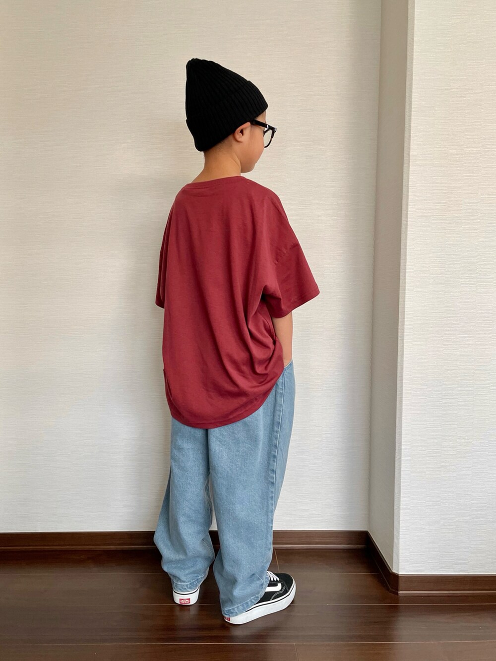 レッド系のTシャツ/カットソー、ブルー系のデニムパンツ、ブラック系のスニーカーを着用したキッズの秋コーディネートの2枚目の写真