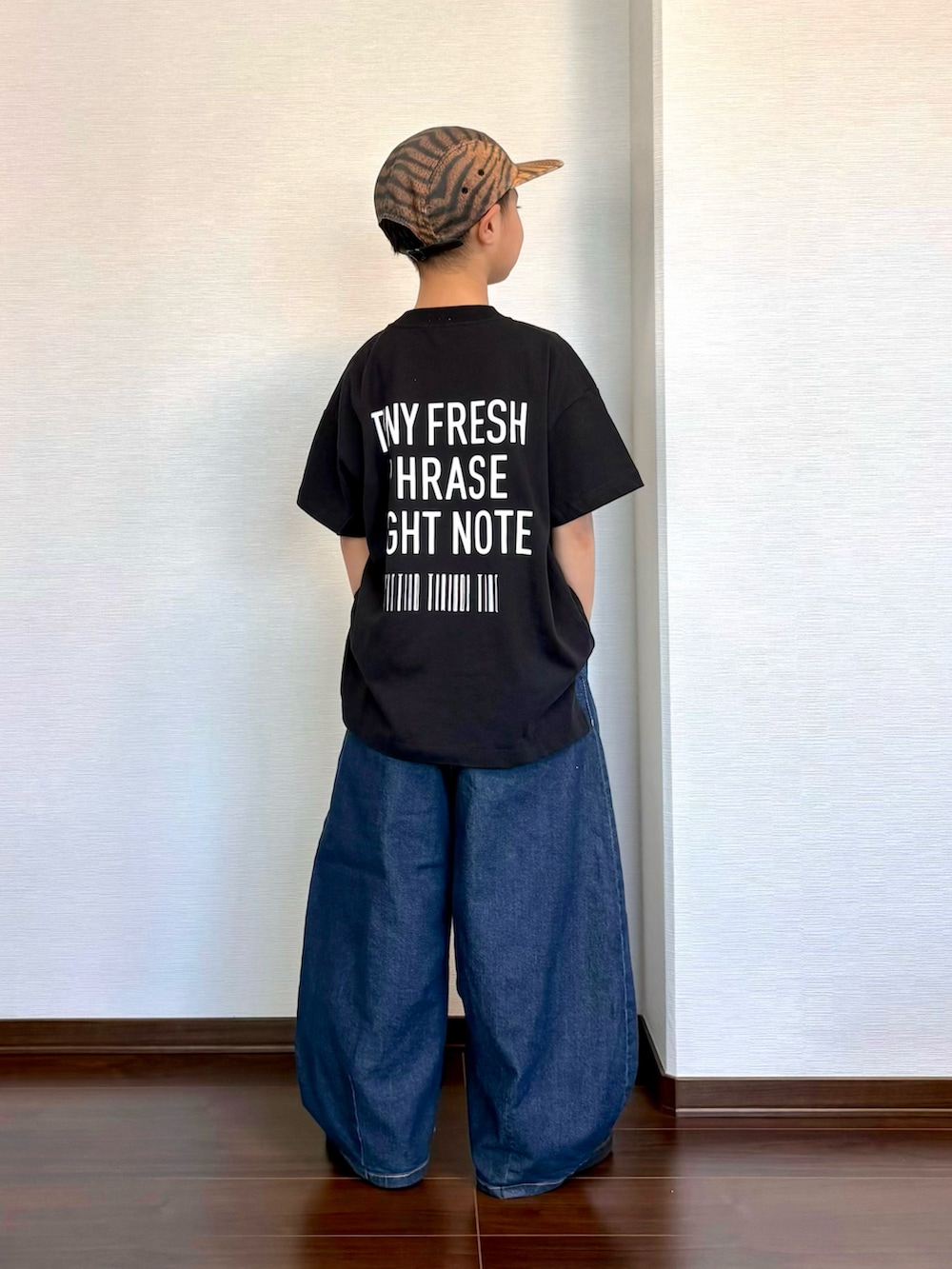 ブラック系のTシャツ/カットソー、ブルー系のデニムパンツ、ブラック系のスニーカーを着用したキッズの夏コーディネートの2枚目の写真