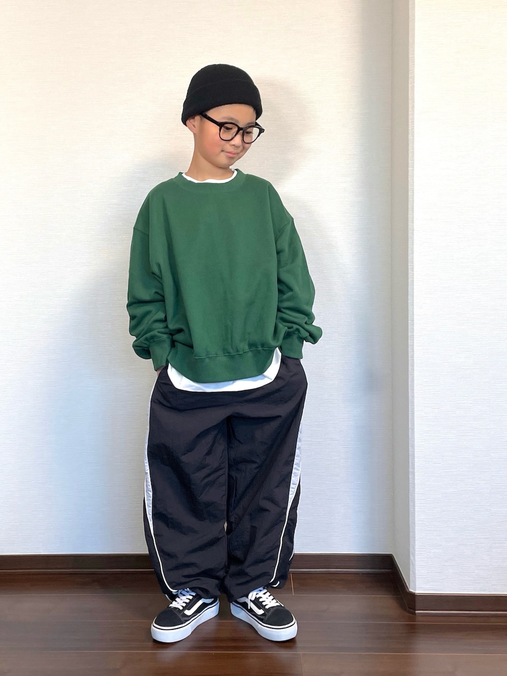 グリーン系のスウェット、ブラック系のその他パンツ、ブラック系のスニーカーを着用したキッズの秋コーディネートの2枚目の写真